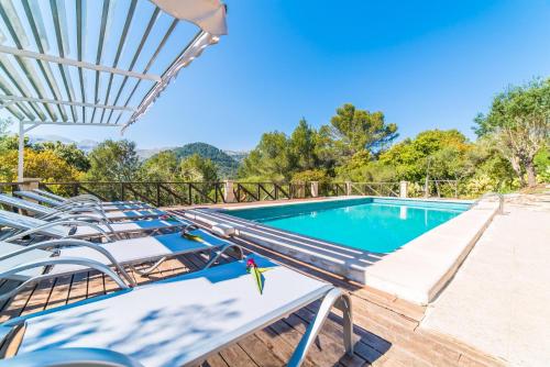 einen Pool mit Liegestühlen und einem Sonnenschirm in der Unterkunft Ideal Property Mallorca - Caselles Petit in Campanet