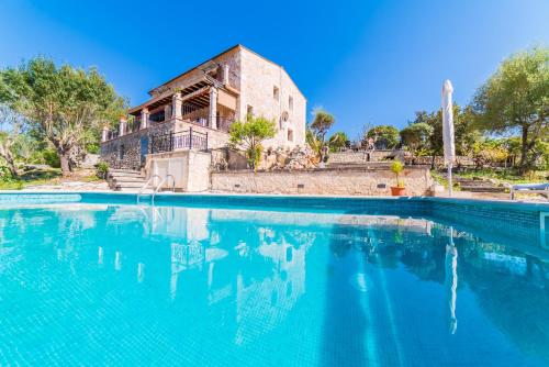 坎帕內特的住宿－Ideal Property Mallorca - Caselles Petit，一座房子反映在游泳池的水中