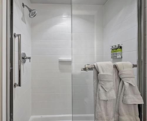 a bathroom with a glass shower stall with towels at Holiday Inn Express Hotel & Suites Lufkin South by IHG in Lufkin
