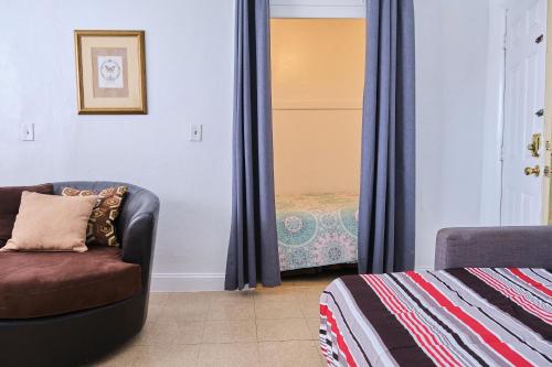 uma sala de estar com uma cadeira e uma cama em Gallo Condo 33/downtown/8st em Miami