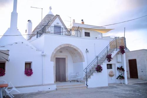 a white church with stairs on the side of it at VALLE D'ITRIA Trullo Sovrano sul Monte in Cisternino