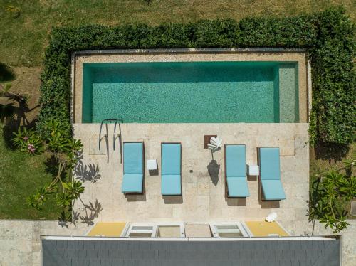 an overhead view of a swimming pool with chairs at The Liming Bequia in Friendship