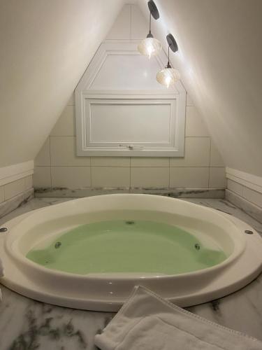 a bathroom with a large tub in a attic at Hotel Fioreze Centro in Gramado