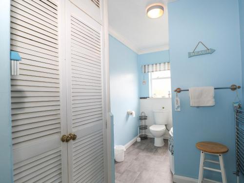 a bathroom with blue walls and a toilet at High Tide in Herne Bay