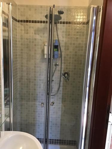una ducha con una puerta de cristal junto a un lavabo en Nido del Cuore, en Turín