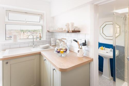 a kitchen with a counter with a sink and a window at *Brand New* Olive Grove Cottage in Torquay