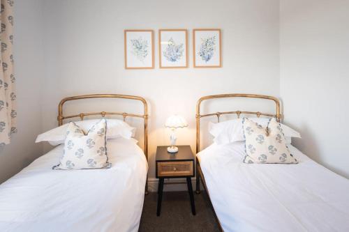 dos camas sentadas una al lado de la otra en una habitación en *Brand New* Olive Grove Cottage, en Torquay