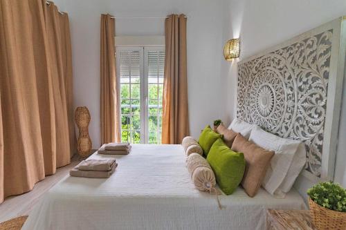 - une chambre avec un grand lit blanc et des oreillers verts dans l'établissement Tenerife Deluxe Villas, à Adeje