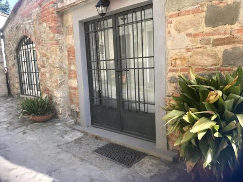 a black door on a brick building with plants at Agriturismo I Poggi in Impruneta