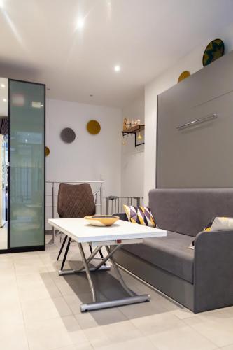 un salon avec une table et un canapé dans l'établissement Petit bijou dans le centre de Paris, à Paris
