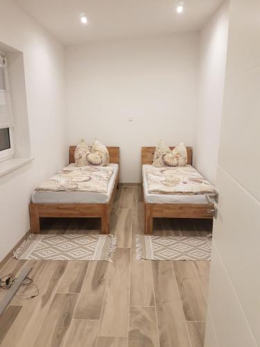 2 camas en una habitación con suelo de madera en Oase am Nationalpark en Kargow