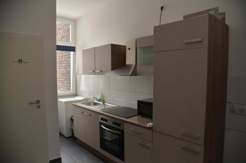 een keuken met een wastafel en een fornuis top oven bij Design Apartments 1 in Dortmund