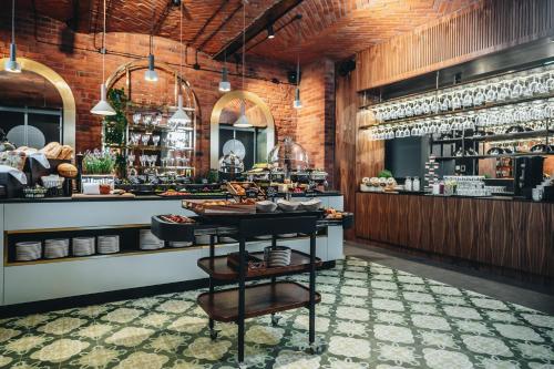 a restaurant with a counter with food on it at Hotel Altus Palace - Destigo Hotels in Wrocław