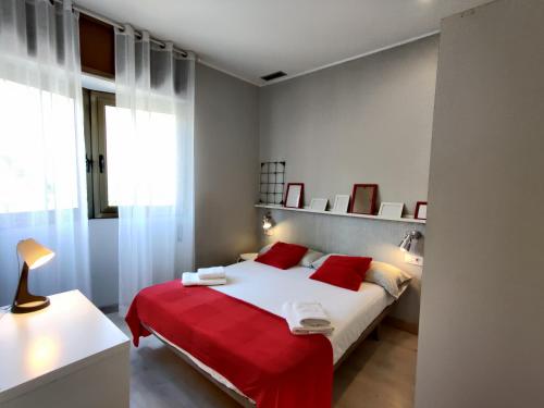 ein Schlafzimmer mit einem großen Bett mit roten Kissen in der Unterkunft Fira Plaza España apartment in Barcelona