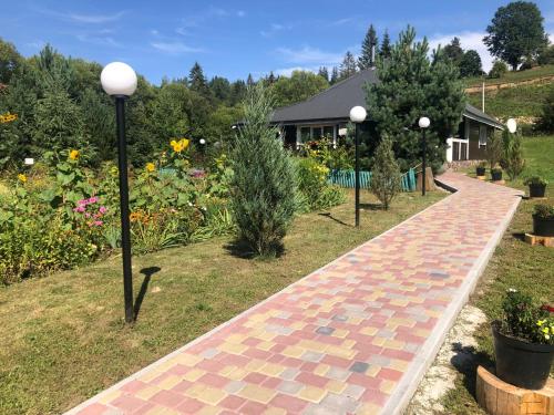 a brick walkway in a garden with flowers at Краєвид in Slavske