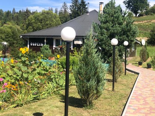 a garden with three lights in front of a house at Краєвид in Slavske