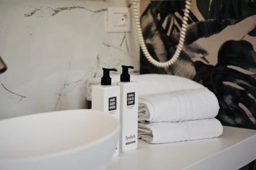 two bottles ofodorizers sitting on a counter next to towels at Torbole Aparthotel in Nago-Torbole