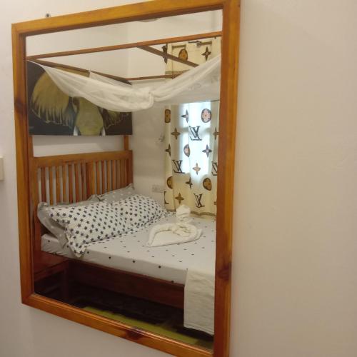 a mirror reflecting a bed in a bedroom at Casa Carlotta & Villa in Nungwi