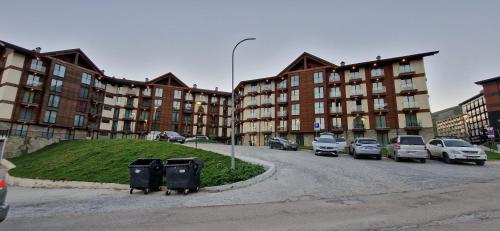 a street with cars parked in front of buildings at New Gudauri Loft 2 - "Mano", near ski lift Gondola in Gudauri