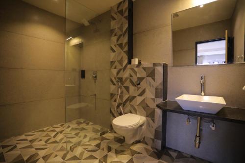 a bathroom with a toilet and a sink and a mirror at Hotel City Express Udaipur - My Downtown Hotels in Udaipur