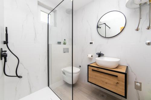 a bathroom with a toilet and a sink and a mirror at Apartments by the sea Podaca, Makarska - 9712 in Podaca