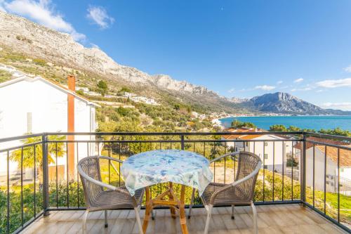 a table and chairs on a balcony with a view of the ocean at Apartments by the sea Podaca, Makarska - 9712 in Podaca