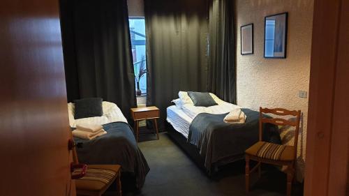 a hotel room with two beds and a window at The Bank Sleeping in Neskaupstaður