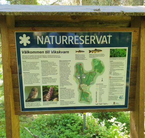 a sign for the nature preserve at the park at Cabin near lake and beautiful nature reserve. in Bodafors