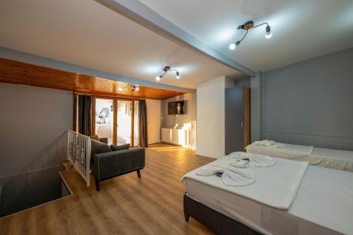 イスタンブールにあるタクシム トレンド スイーツのベッド2台、ソファ、椅子が備わる客室です。