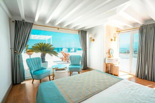 1 dormitorio con 1 cama, 2 sillas y una ventana grande en Pacco Hotel & SPA en Antalya