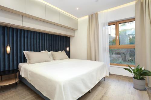 a bedroom with a large white bed and a window at Apartments by the sea Podstrana, Split - 9714 in Podstrana