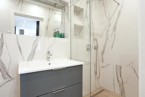 a bathroom with a sink and a shower at Apartments by the sea Podstrana, Split - 9714 in Podstrana
