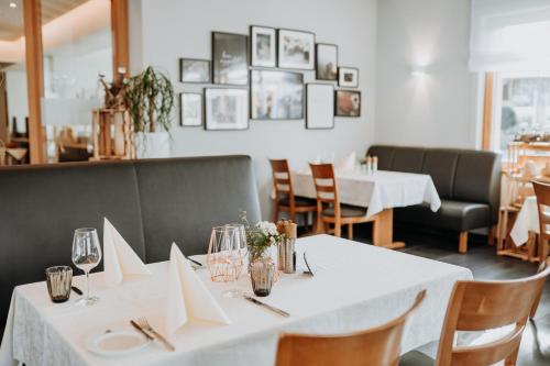 a dining room with a white table and chairs at Hotel Restaurant zur Marienburg in Pünderich