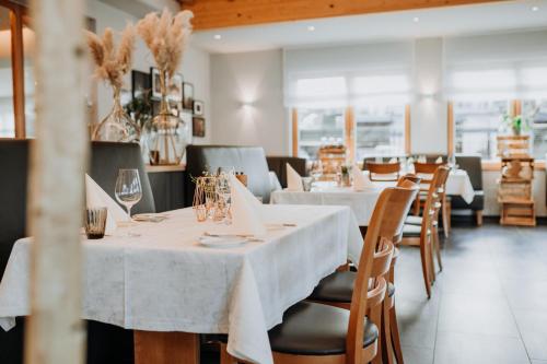 a dining room with white tables and chairs at Hotel Restaurant zur Marienburg in Pünderich