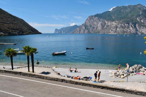 a group of people on a beach in the water at Torbole Aparthotel in Nago-Torbole