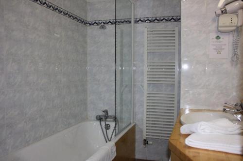 a bathroom with a bath tub and a sink at Le Castillan in L'Alpe-d'Huez