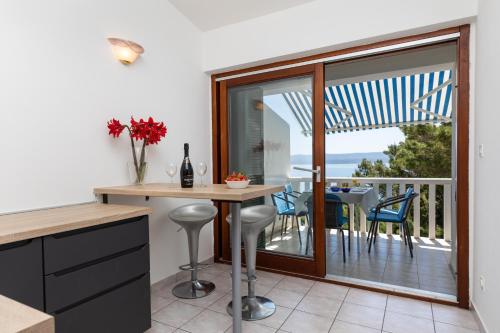 kuchnia ze stołem i krzesłami oraz balkon w obiekcie Apartments by the sea Mimice, Omis - 2736 w Mimicach
