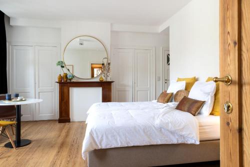 a bedroom with a bed with a mirror and a table at Blauwe Huis B&B in Nieuwpoort