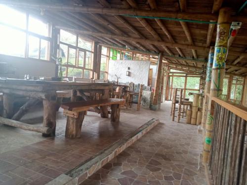 Habitación con mesa y bancos en un edificio en Hakuna Matata Glamping timon, en Salento