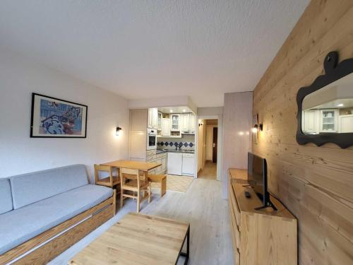un salon avec un canapé, une télévision et une table dans l'établissement Studio cosy sud-ouest proche pistes avec balcon - 4 pers - FR-1-449-117, à Tignes