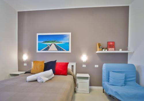 a bedroom with a bed and a blue chair at I giardini dell'Olimpo in Paestum