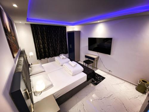 a bedroom with a bed with white pillows and a tv at NRing Villa am Nürburgring in Adenau