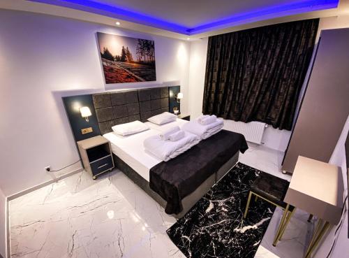 um quarto com uma cama com lençóis brancos e almofadas em NRing Villa am Nürburgring em Adenau
