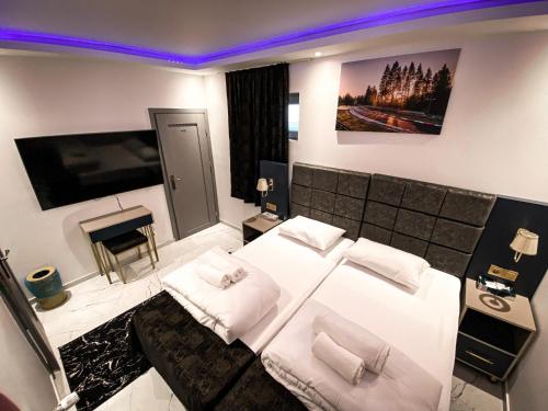 a bedroom with a large white bed and a fireplace at NRing Villa am Nürburgring in Adenau