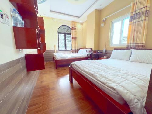 Hà Anh Hotel في بلاي كو: غرفة نوم بسرير كبير وأريكة