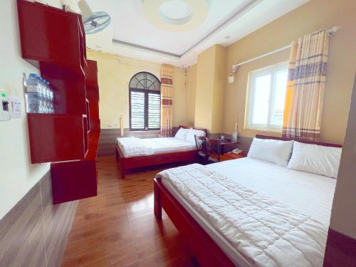 Hà Anh Hotel في بلاي كو: غرفة نوم بسريرين واريكة فيها