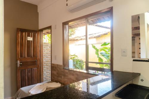 a kitchen with a counter top and a window at PV Pousada Passarela da Vila in Itacaré