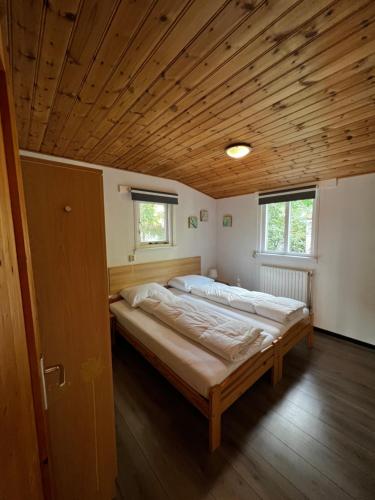 een groot bed in een kamer met een houten plafond bij Boszicht in Diever