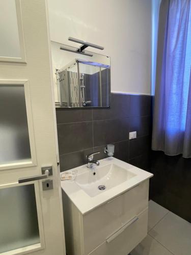 ein Badezimmer mit einem weißen Waschbecken und einem Spiegel in der Unterkunft Le Tre Rose in Terrasini