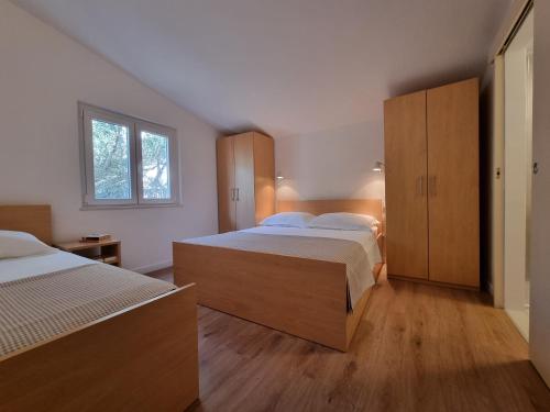 a bedroom with two beds and wooden cabinets at Apartment Duce 2821c in Duće